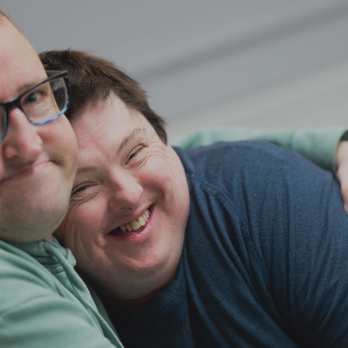 Two people we support at Score have a cuddle. Day Opportunities Centres like Score enable people to build up their social circle in a safe, supportive environment, while enjoying activities and trying new things.