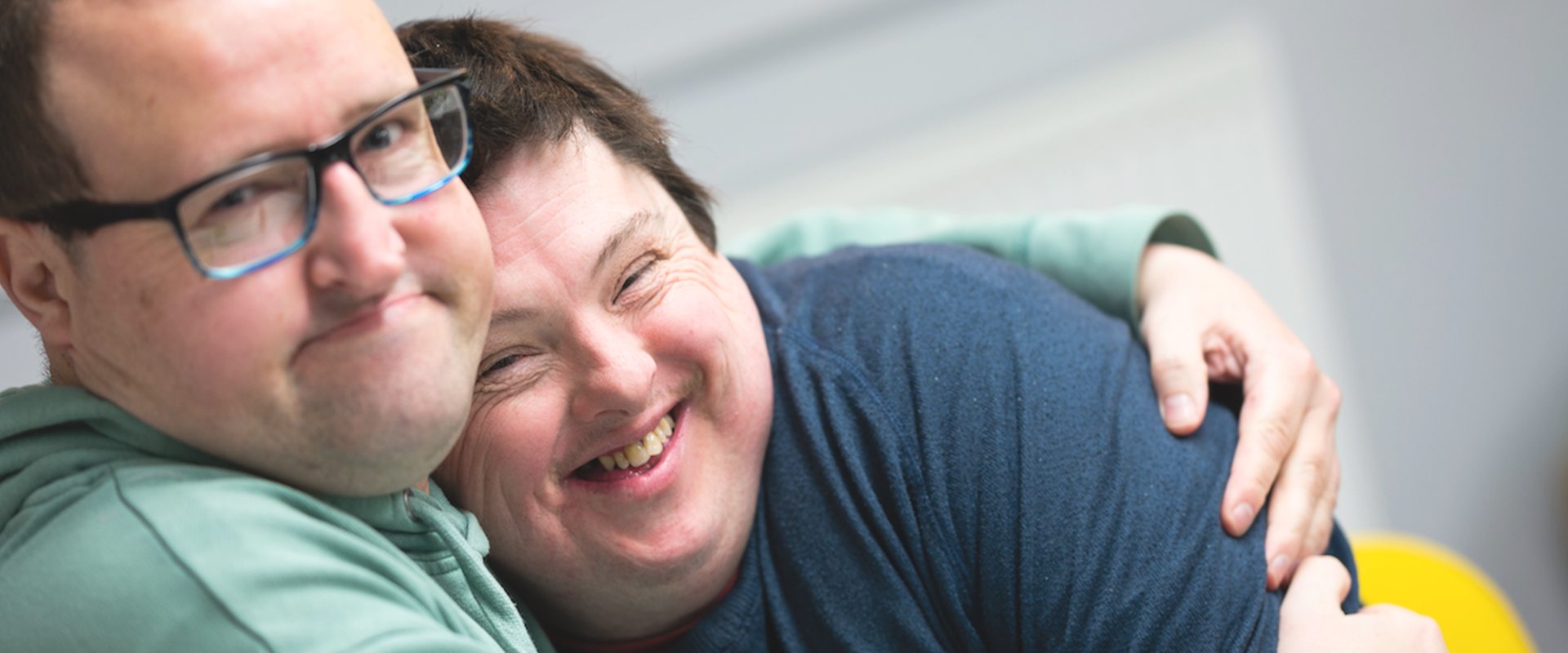 Two people we support at Score have a cuddle. Day Opportunities Centres like Score enable people to build up their social circle in a safe, supportive environment, while enjoying activities and trying new things.