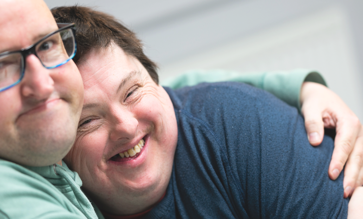 Two people we support at Score have a cuddle. Day Opportunities Centres like Score enable people to build up their social circle in a safe, supportive environment, while enjoying activities and trying new things.