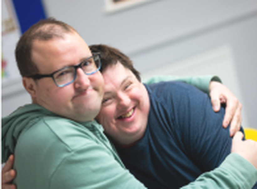 Two people we support at Score have a cuddle. Day Opportunities Centres like Score enable people to build up their social circle in a safe, supportive environment, while enjoying activities and trying new things.